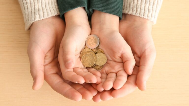 Hands of woman and son holding coins