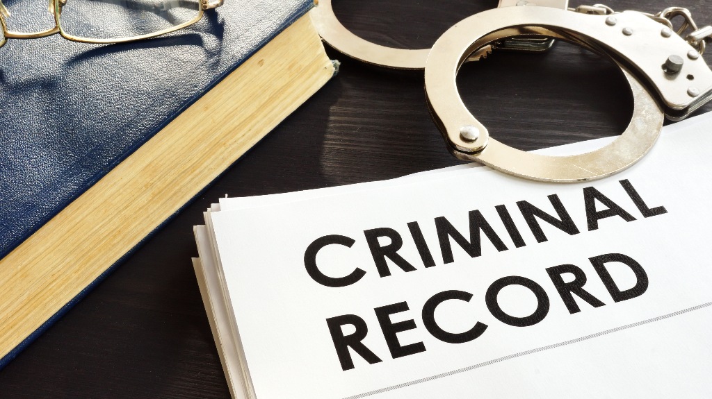Criminal record and handcuffs on a desk