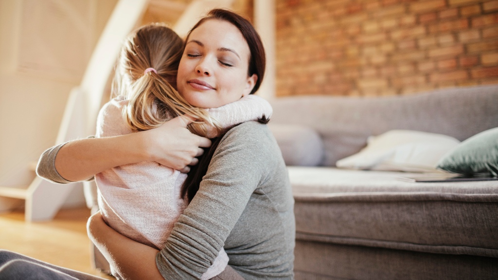 mother hugging her little daughter at home