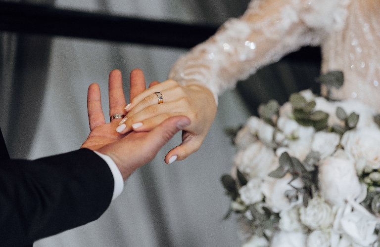 A bride and groom are holding hands