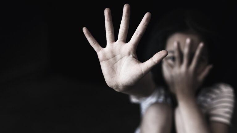 little girl extends her hand forward in a stop gesture