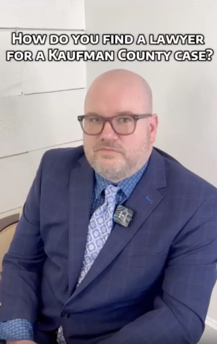 Professional man in blue suit and glasses seated, text above reads "How do you find a lawyer for a Kaufman County case?