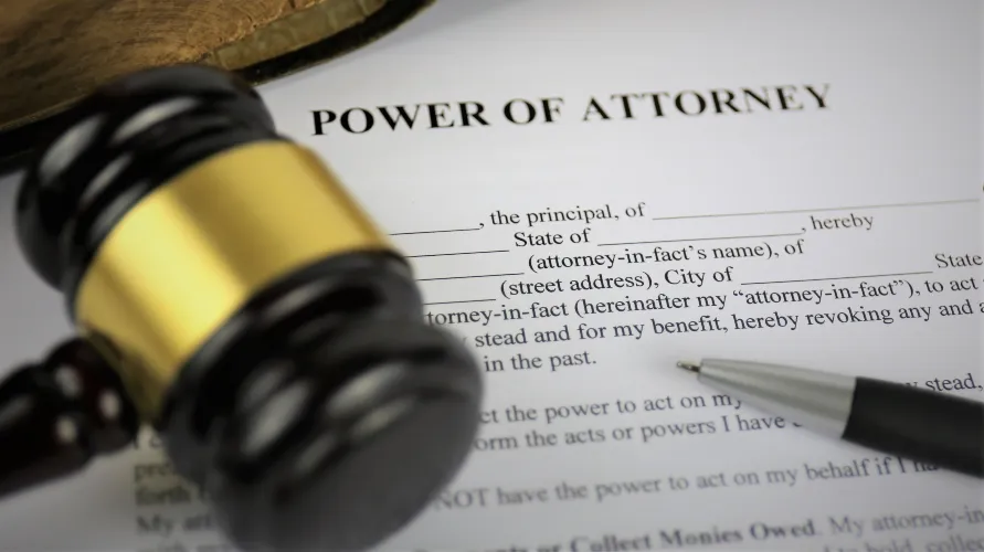Close-up of a Power of Attorney document with a wooden gavel and pen.